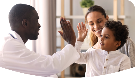 Auf dem Schoss seiner Mutter sitzender Junge gibt Erwachsenem High-Five