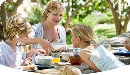 Kinder, die ihrer Mutter bei der Zubereitung des Frühstücks helfen
